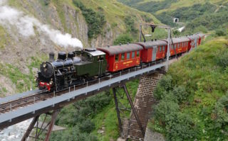 Uno de los trenes de la línea de la Furka pasando sobre el puente plegable del Steffenbach.