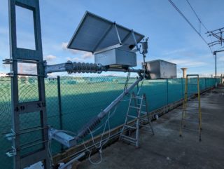 Pruebas de integración en la campa de TELICE del prototipo TELICE DYNTACT® de sensor de comportamiento dinámico del contacto pantógrafo-catenaria. Se aprecia la construcción del sistema sobre un soporte de ménsula tubular, la caja de electrónica, el panel fotovoltaico, la estación meteorológica y la carcasa de la cabeza activa del sensor.